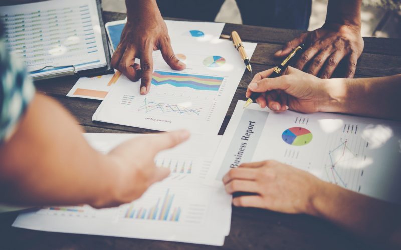 Group of business people analysis with marketing report graph, Young specialists are discussing business ideas for new digital start up project.