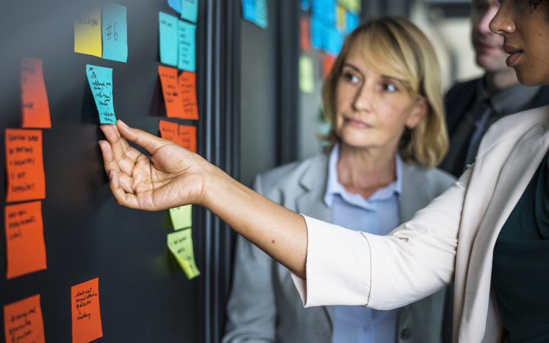 Businesspeople planning tasks with sticky notes