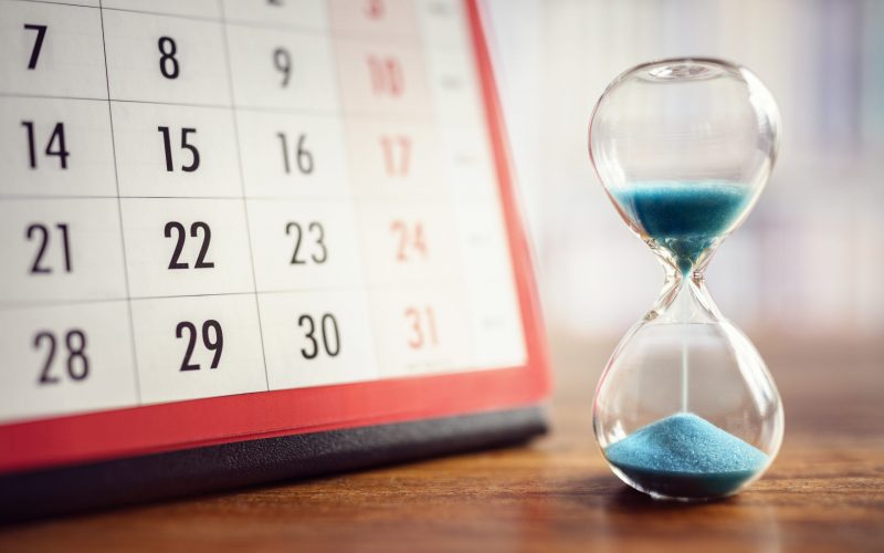 Hour glass and calendar concept for time slipping away for important appointment date, schedule and deadline