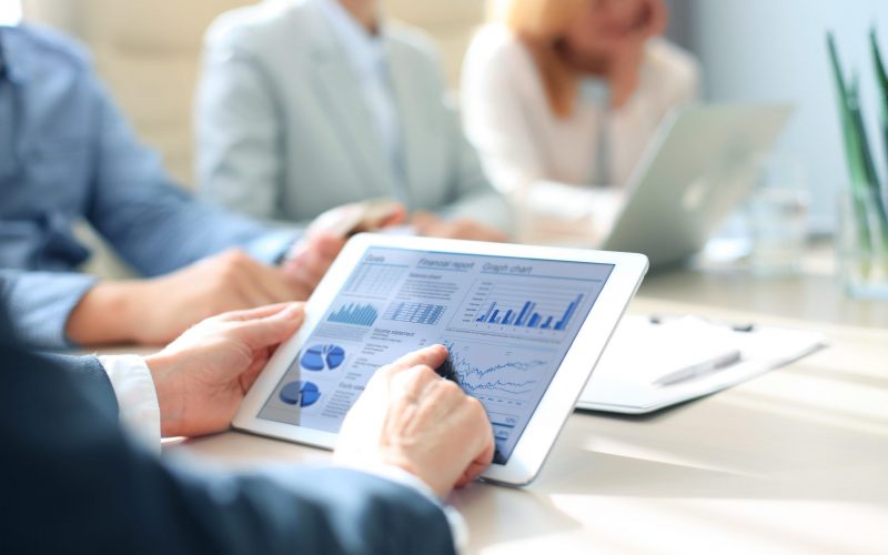 Business person analyzing financial statistics displayed on the tablet screen