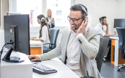 Portrait of happy smiling customer support phone operator at workplace.