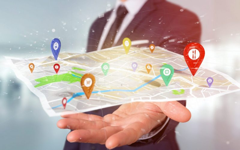 View of a Businessman holding a 3d rendering pin holder on a map