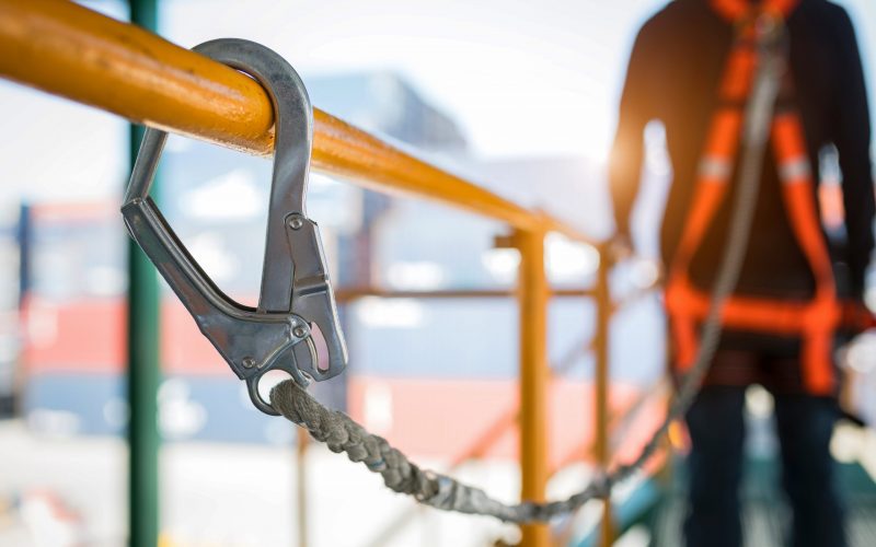 Construction worker wearing safety harness and safety line working at high place