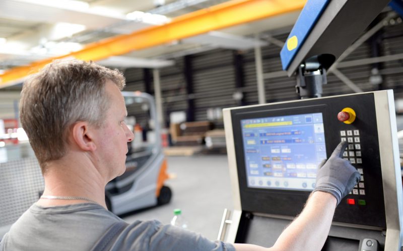 arbeiter bedient eine moderne abkanntbank Maschine im Metallbau // workers operates a modern bench machine in metal construction
