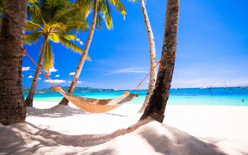 View of cozy straw hammock on the tropical white beach